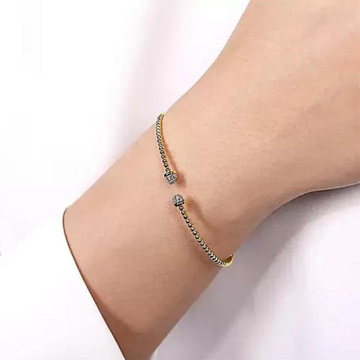 14K gold beaded bangle bracelet with diamond accents, shown on a wrist.