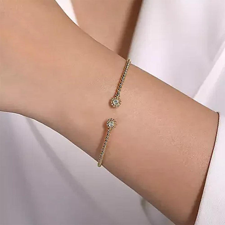 14K gold split cuff bracelet adorned with diamond accents.