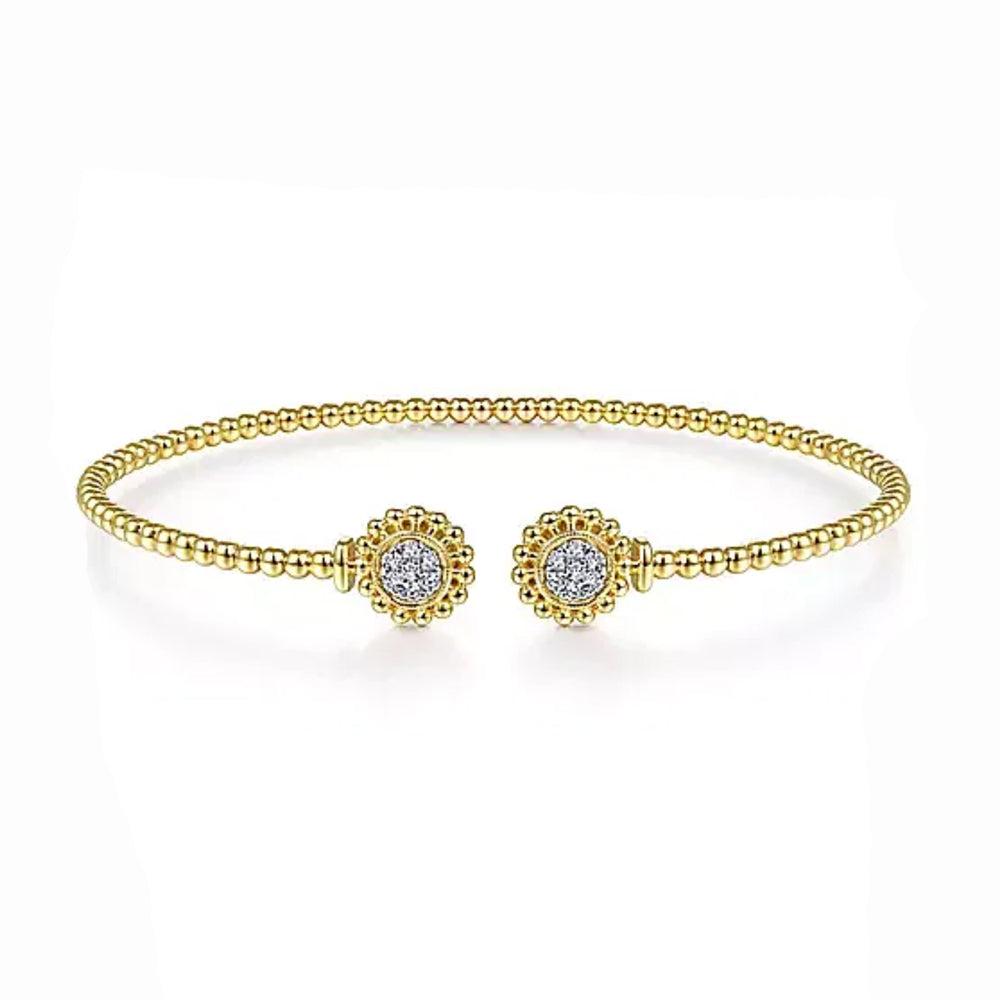 Gold beaded bangle bracelet featuring pave diamond accents.
