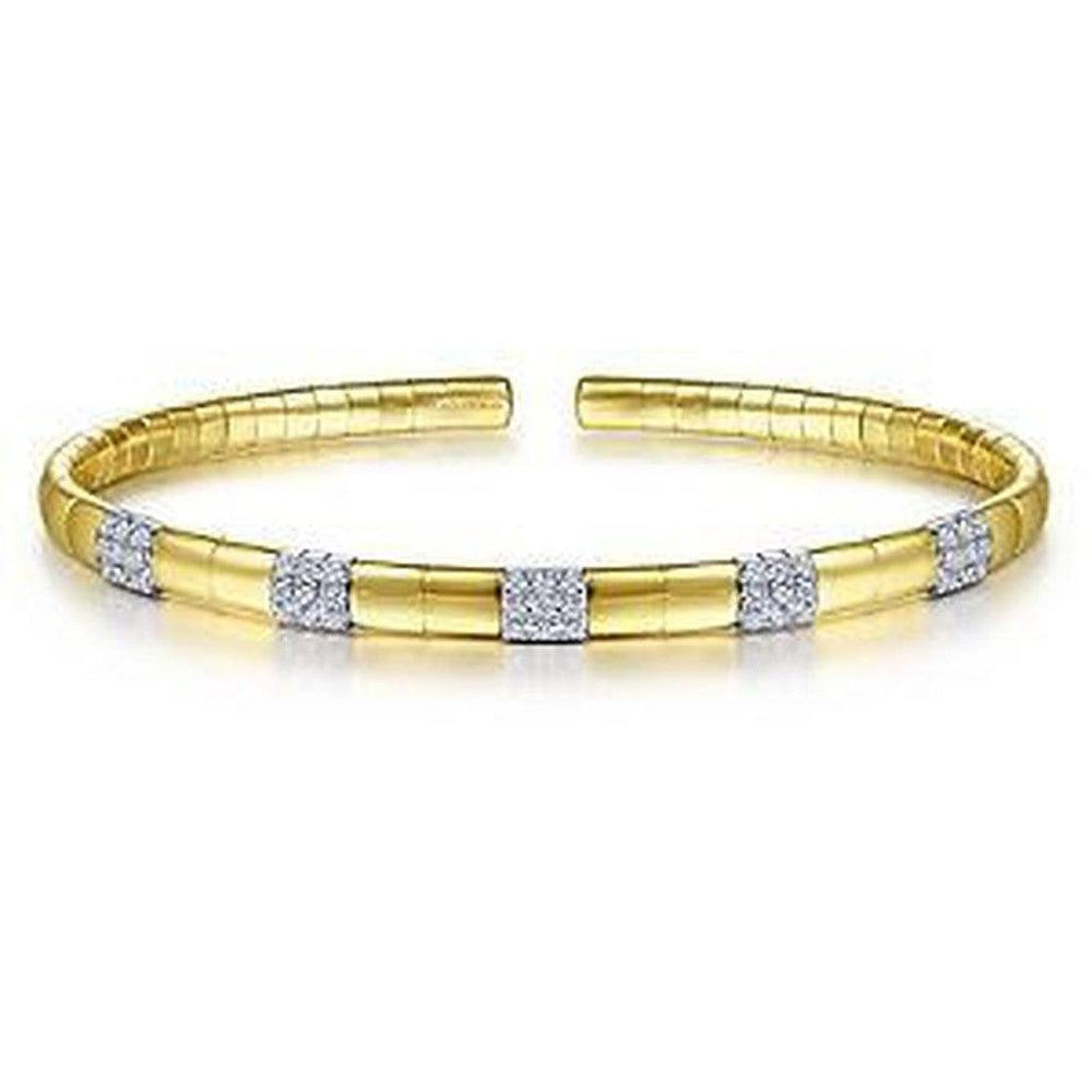 Gold cuff bracelet adorned with pave diamond accents.