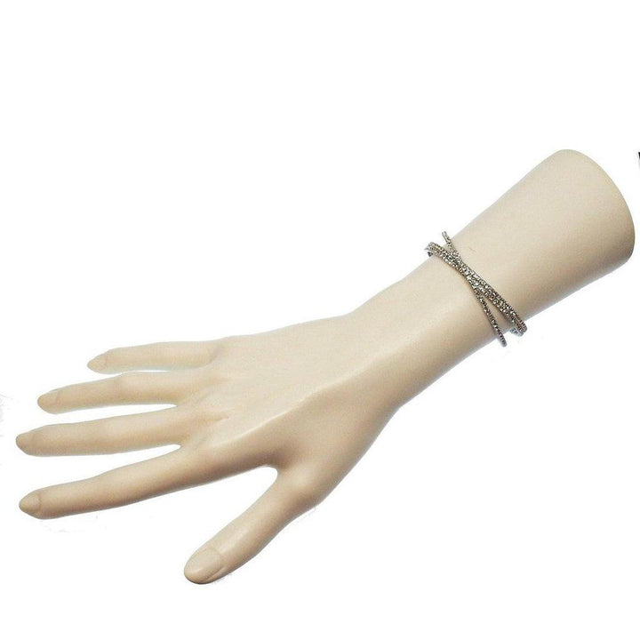 Silver cuff bracelet featuring three rows of sparkling crystals on a mannequin wrist.