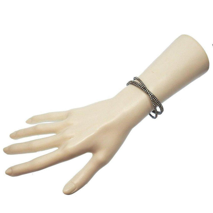 Triple-row hematite crystal cuff bracelet on a mannequin wrist.