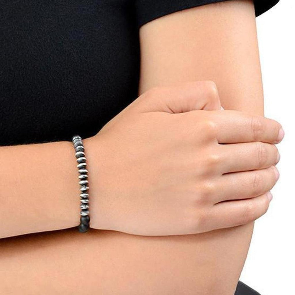 Black onyx beaded bracelet with silver accents, worn on a wrist.