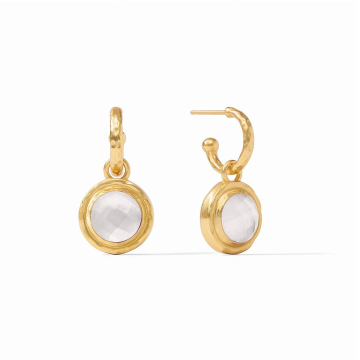 Gold hoop earrings with a dangling white gemstone charm.