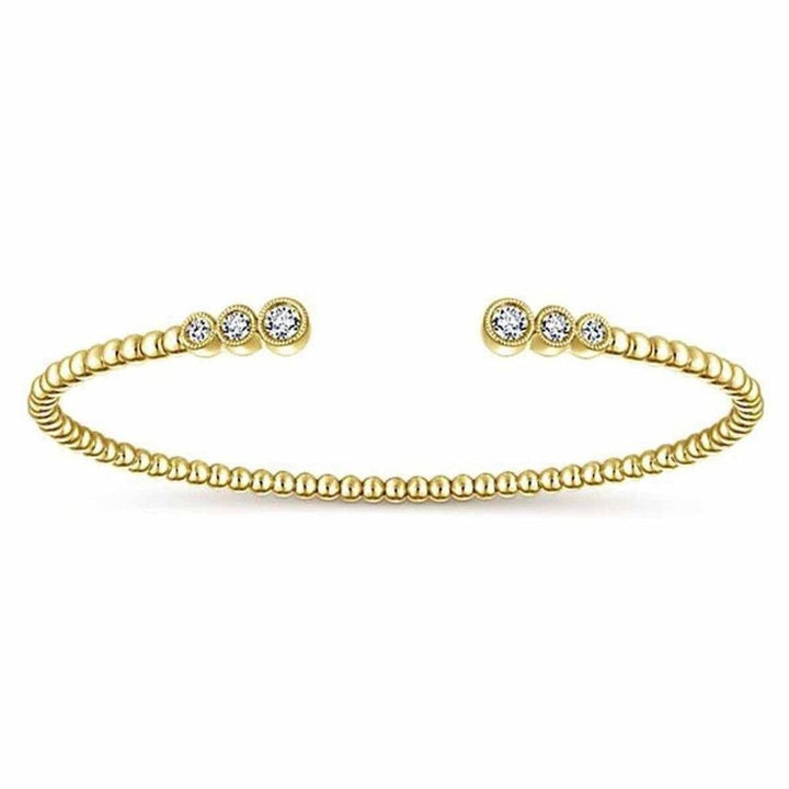 Gold beaded bangle bracelet featuring three bezel-set diamonds.