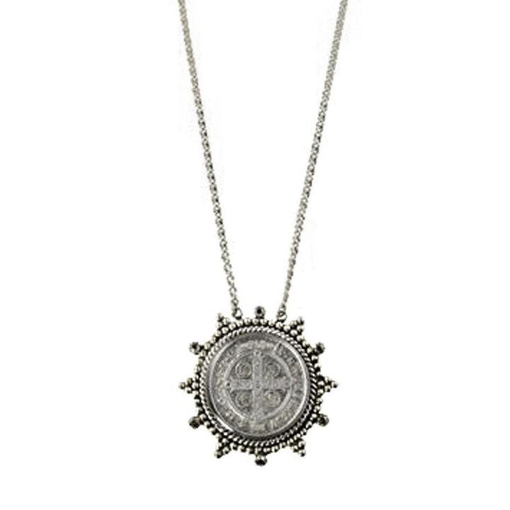 Silver necklace featuring a circular coin pendant with a cross design, accented with beaded detailing.
