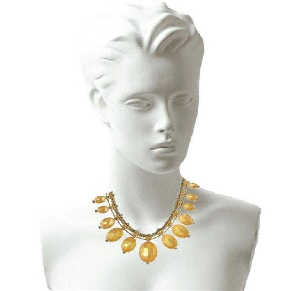 Gold statement necklace with amber oval beads, displayed on a mannequin.