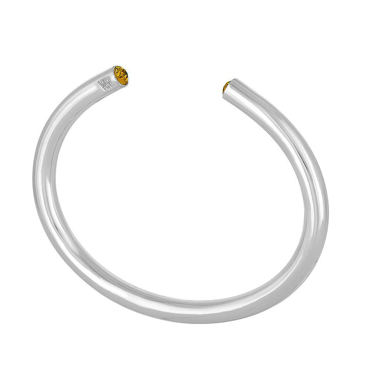 Silver cuff bracelet featuring a yellow gemstone.