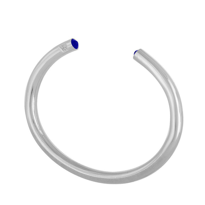 Silver cuff bracelet featuring a small blue gemstone.