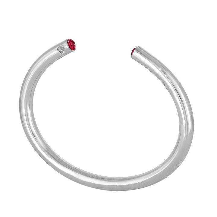 Silver cuff bracelet adorned with a vibrant red gemstone.