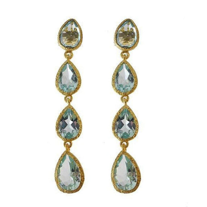 Elegant blue topaz drop earrings with three pear-shaped stones and gold settings.