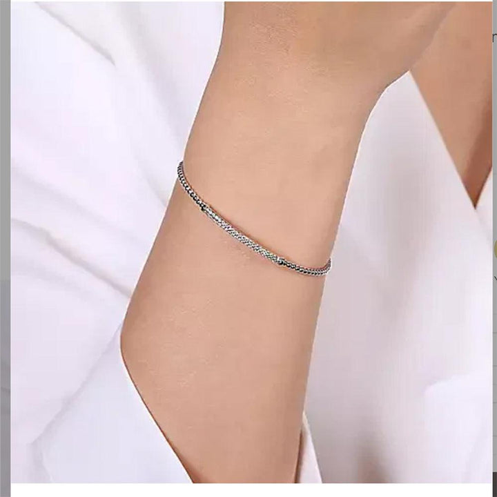 White gold pave diamond bar bracelet on a wrist.