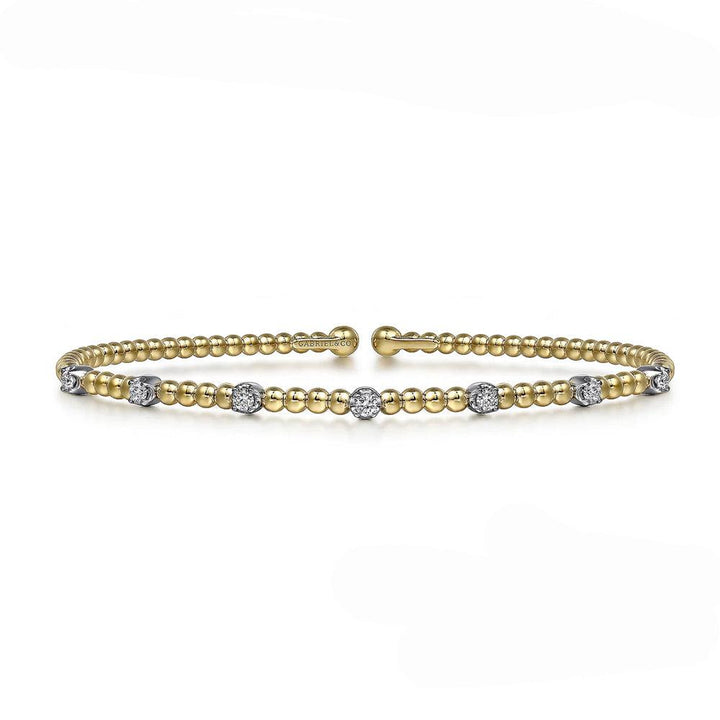 Yellow gold beaded bangle bracelet adorned with sparkling diamond accents.