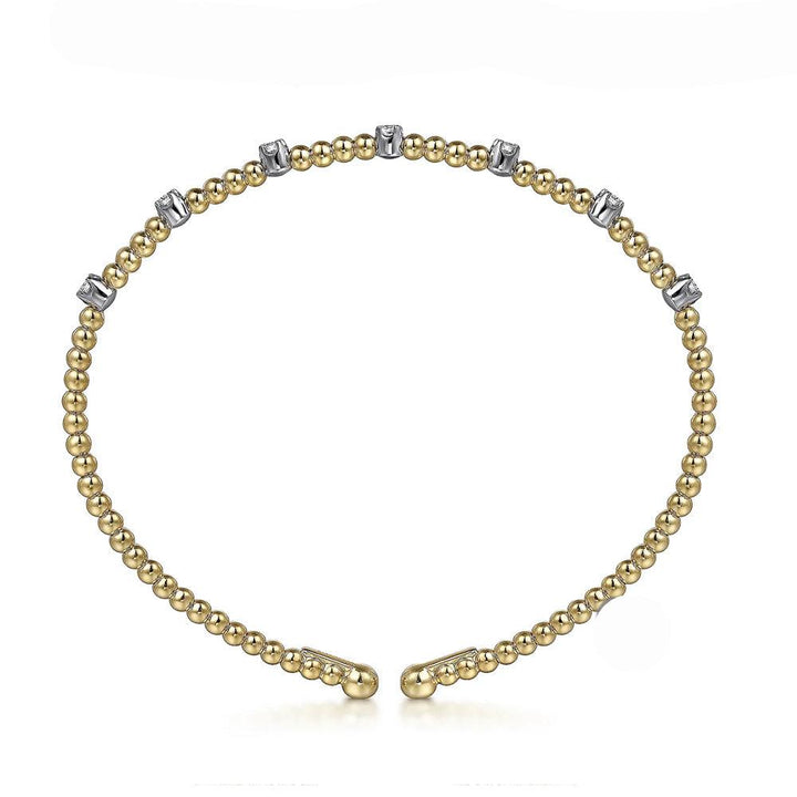 Yellow gold beaded bracelet adorned with small diamonds.