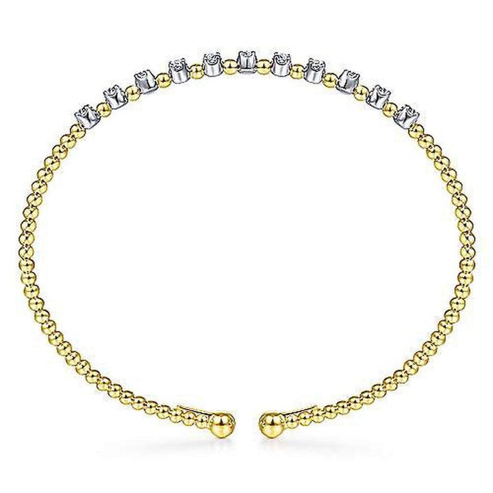Gold beaded cuff bracelet adorned with a row of shimmering diamonds.
