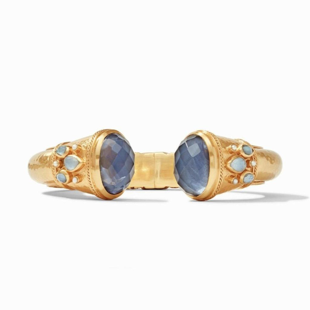 Gold hinge cuff bracelet with blue gemstones and delicate accents.