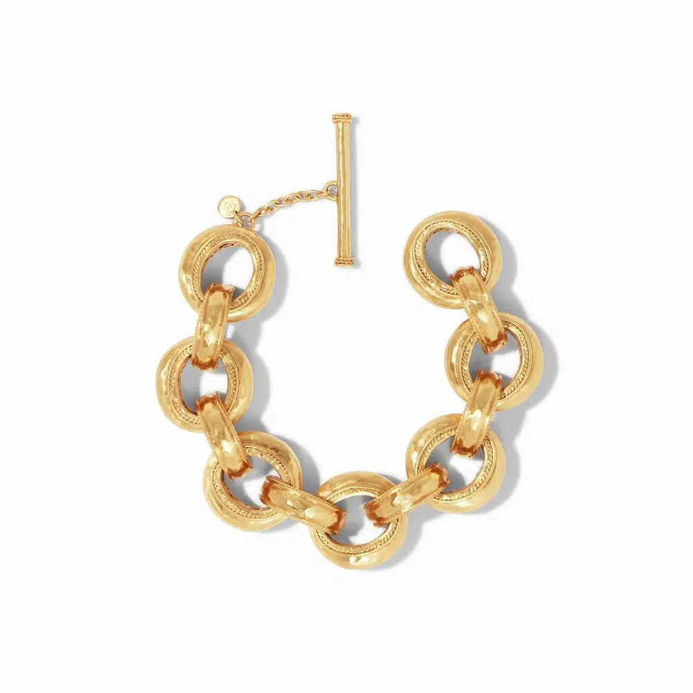 Gold statement bracelet featuring large, textured circular links and a toggle clasp.