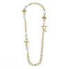 Gold chain necklace with baroque pearls and ornate cross charms.