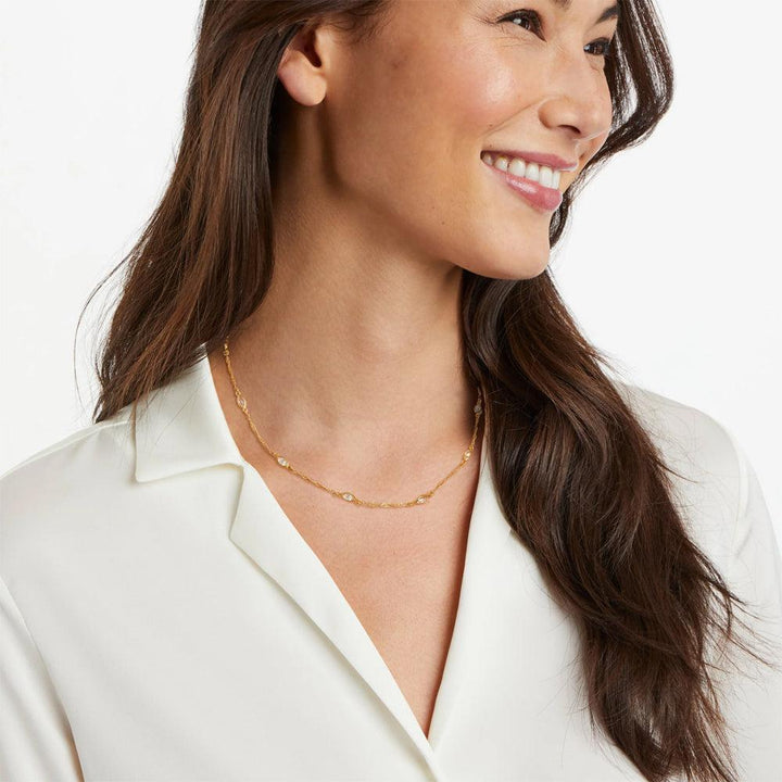 Gold chain necklace with clear stones, worn by a model.