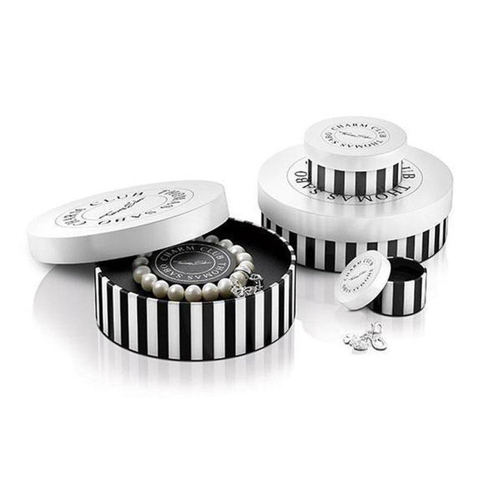 Pearl bracelet in black-and-white striped box, nestled within larger gift packaging.