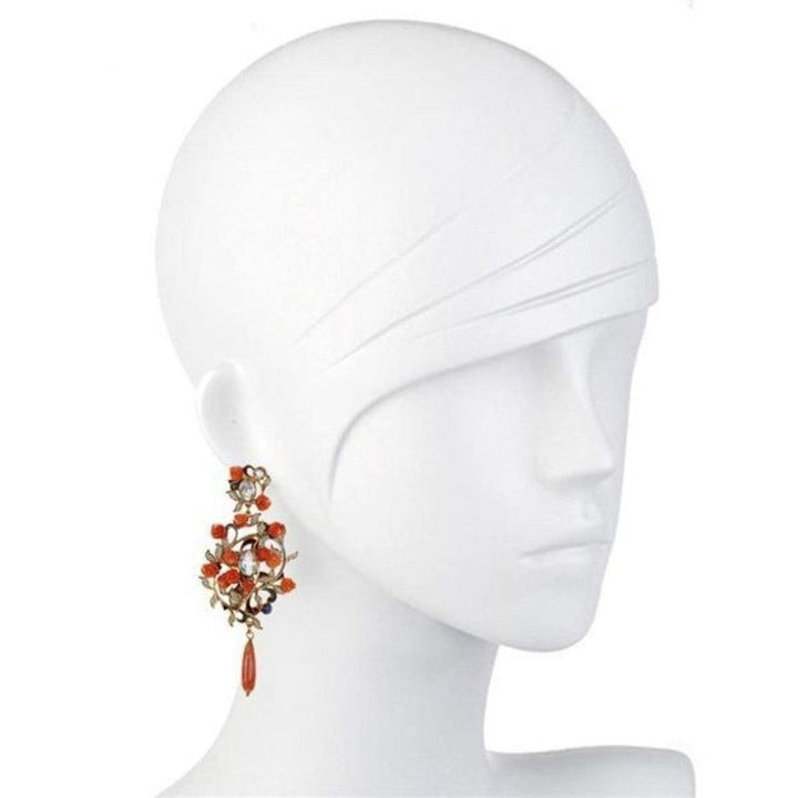 Elegant coral and rose gold drop earrings on a mannequin.