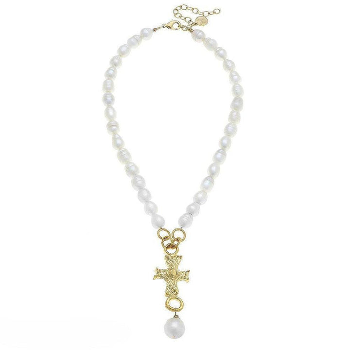Gold cross pendant necklace on a pearl strand; elegant, faith-inspired jewelry.