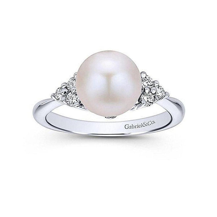 Elegant white gold ring featuring a cultured pearl and diamond accents.