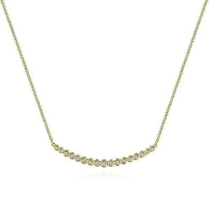 Curved diamond bar necklace in 14k yellow gold with bezel-set diamonds.
