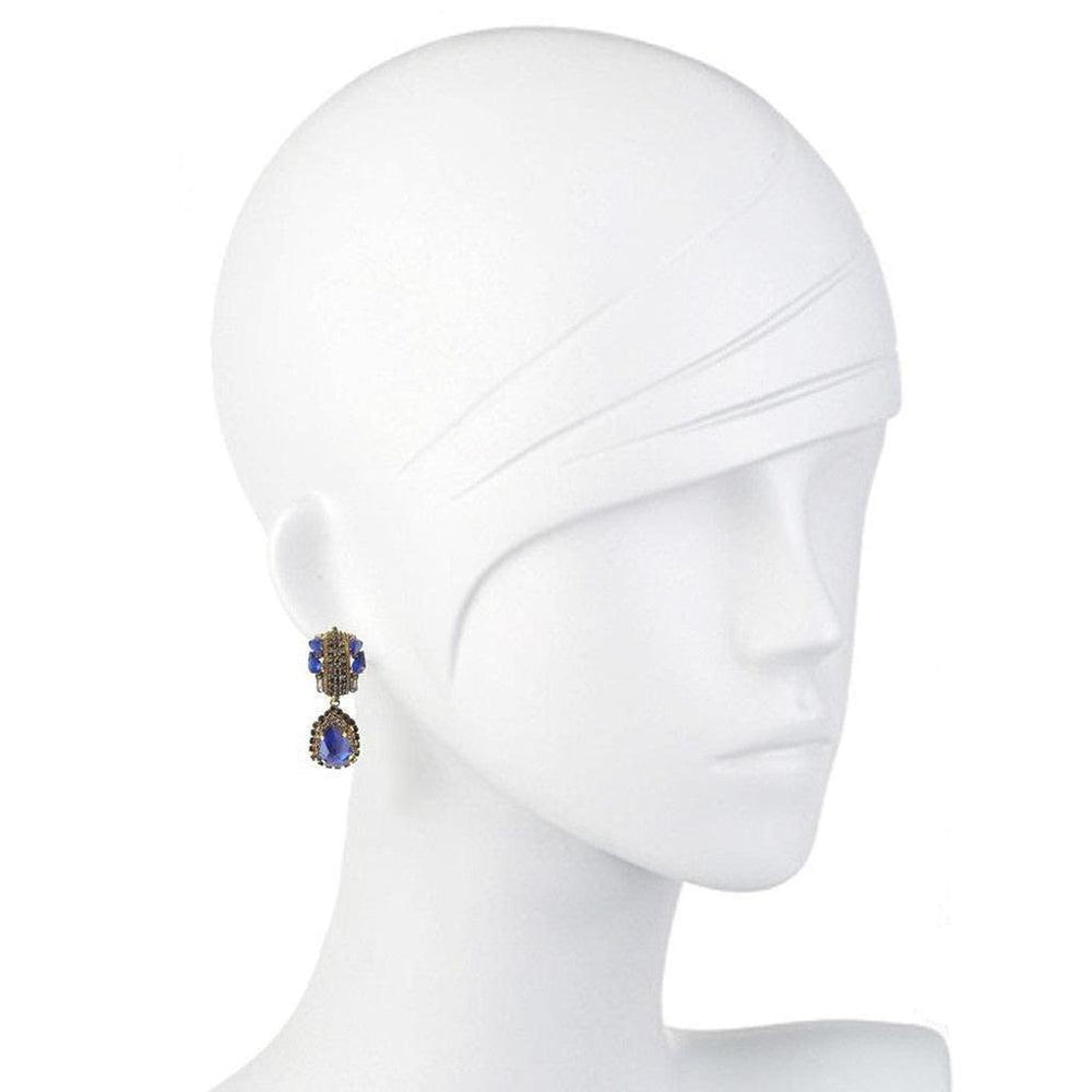 Sapphire and gold drop earrings on a mannequin.