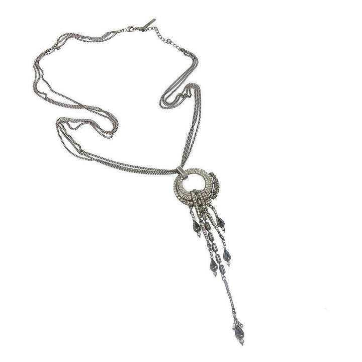 Elegant silver necklace with crystal and dark stone accents, featuring a layered chain and dangling pendant.