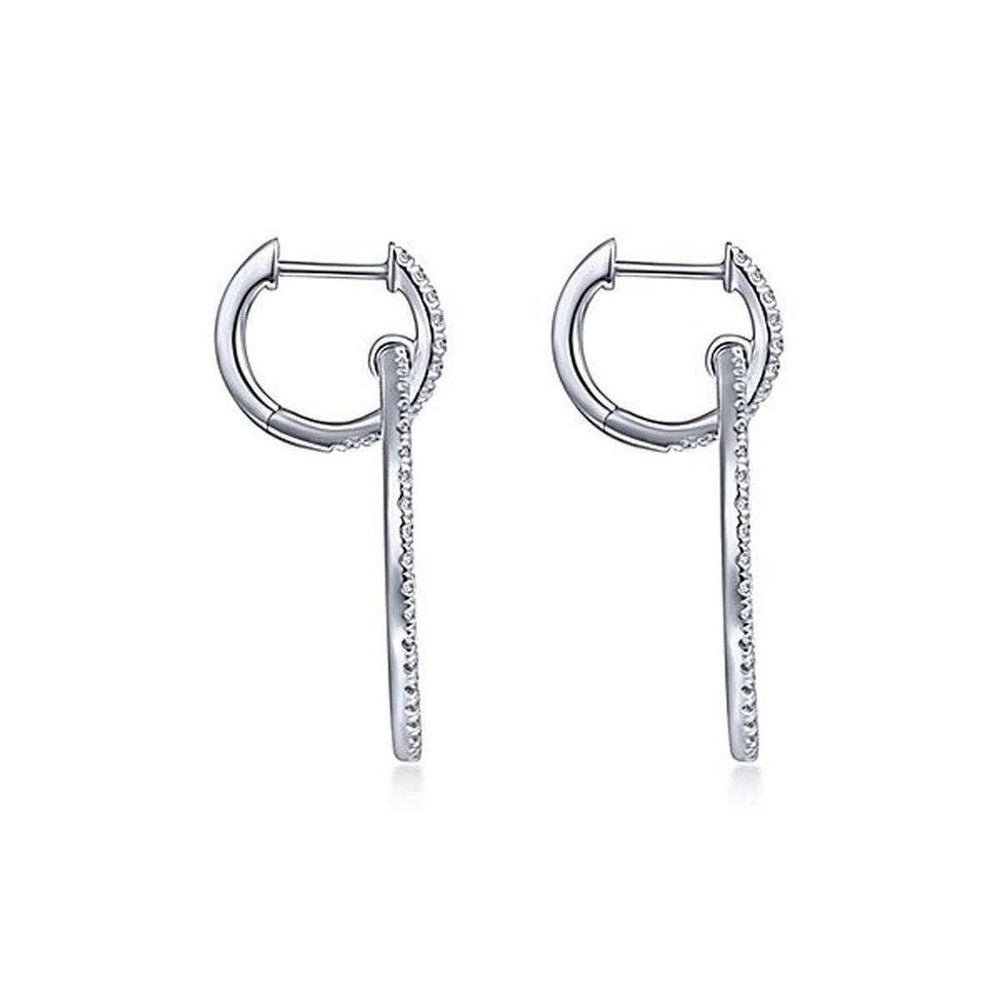 Diamond huggie earrings with dangling diamond accents.