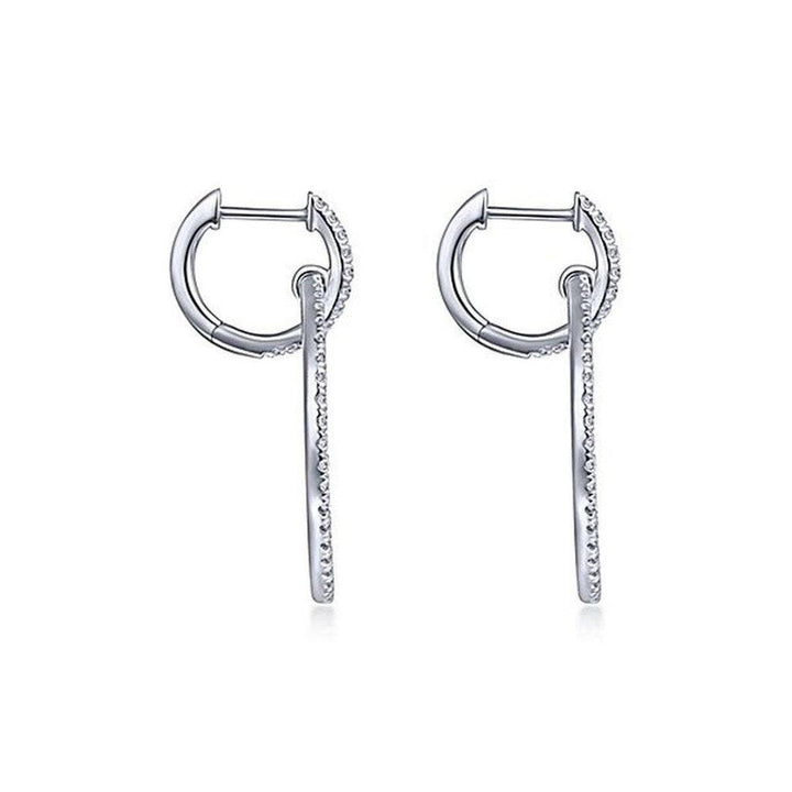 Diamond huggie earrings with dangling diamond accents.