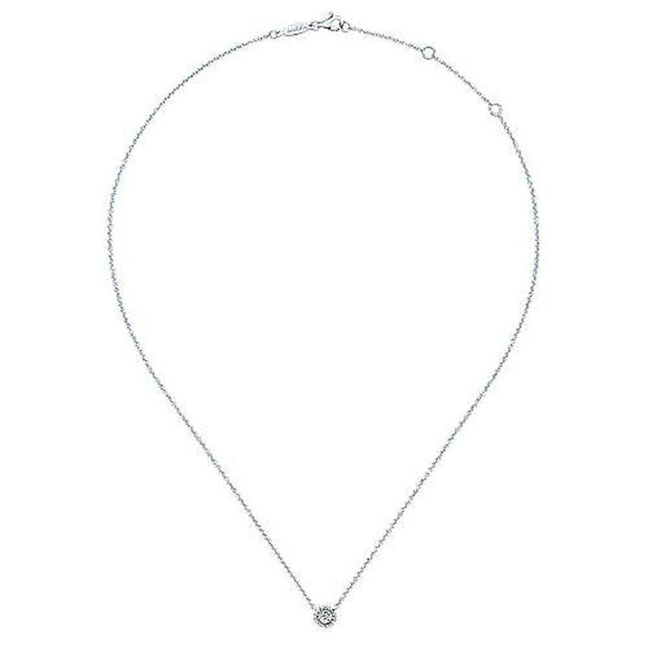 Dainty diamond pendant necklace on a delicate chain.