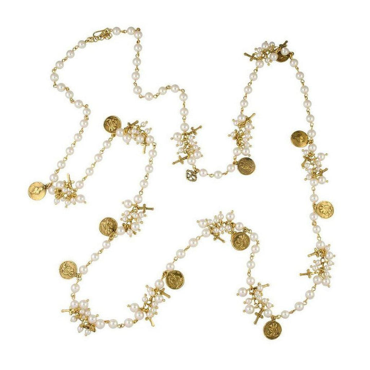 Long pearl necklace with gold charms and crosses; elegant, ornate design.