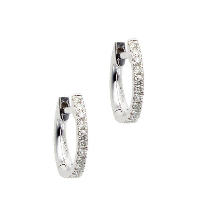 Petite diamond huggie earrings; small, silver hoops with pave diamonds.