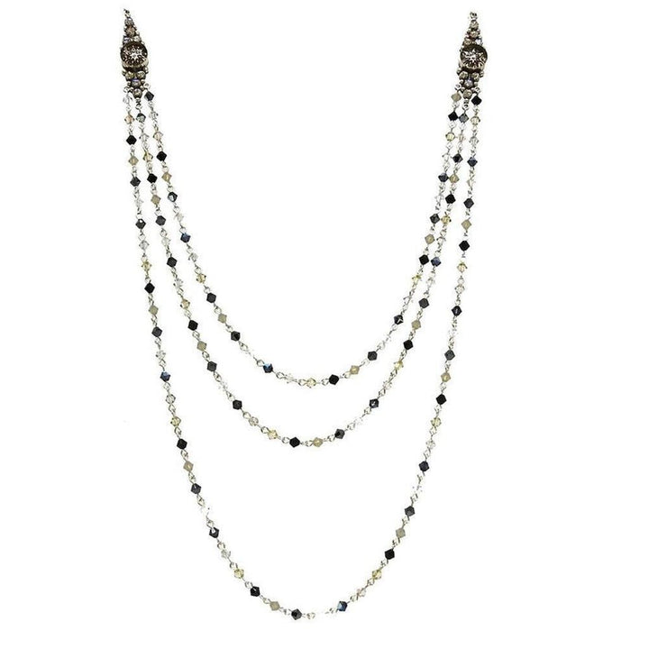Three-strand crystal necklace with dark and light gray beads, silver chain, and ornate accents.