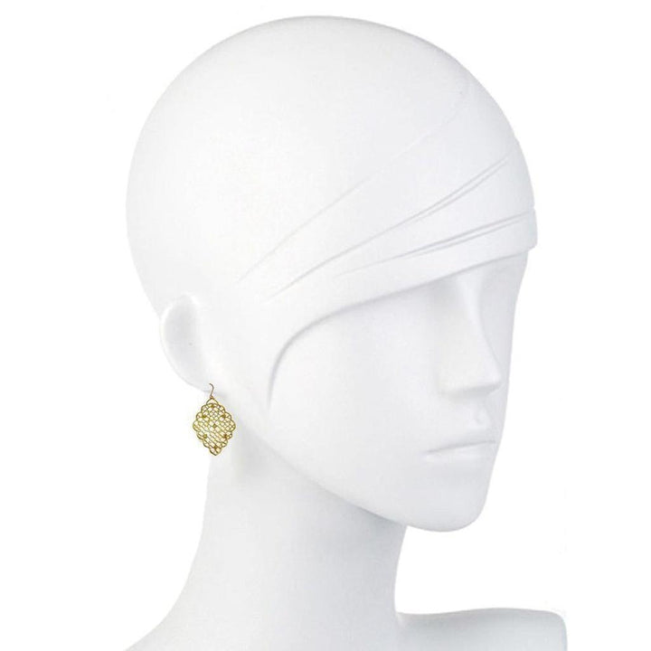 Gold filigree dangle earrings on a mannequin.
