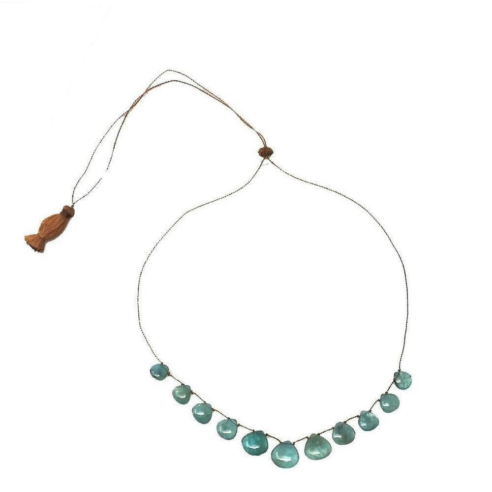 Floating Grandorite Tassel Necklace: Teal gemstone beads on brown cord with tassel.