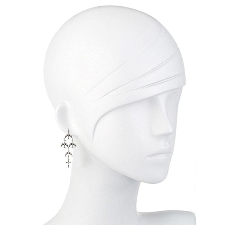 Silver bird and cross dangle earrings on mannequin.