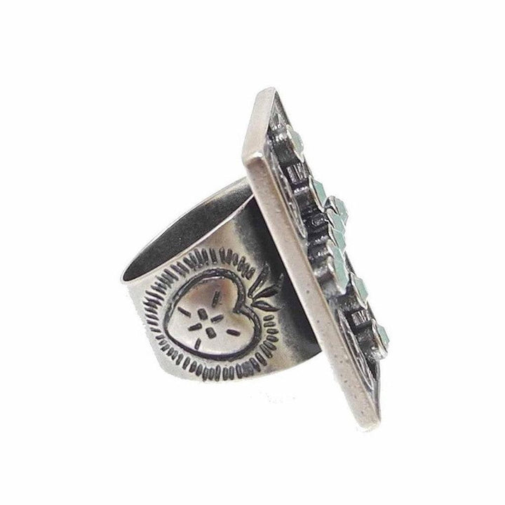 Sterling silver ring featuring a rectangular turquoise stone setting and engraved heart detail.