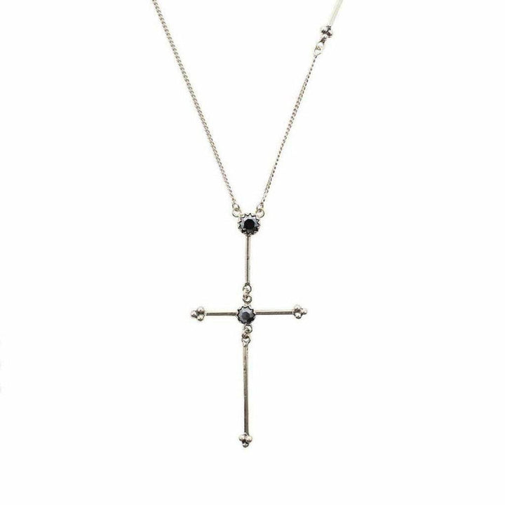 Silver cross necklace with dark gemstones, delicate chain.