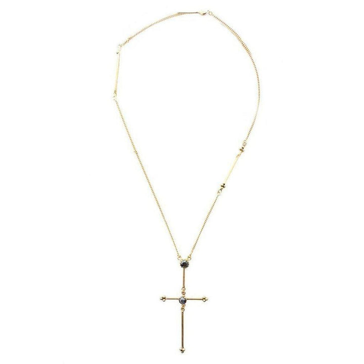Gold cross necklace with dark gemstones, delicate chain.