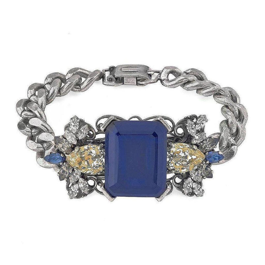 Geometric Crystal Cluster Bracelet: Silver chain bracelet featuring a large blue gemstone, accented with clear and yellow crystals.