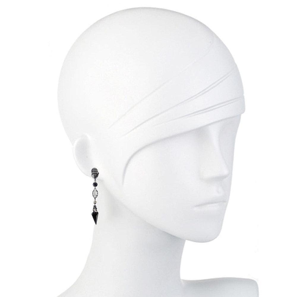 Black and white drop earrings on a mannequin, featuring geometric accents.