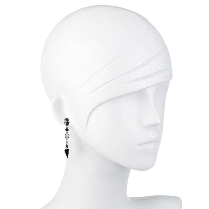 Black and white drop earrings on a mannequin, featuring geometric accents.