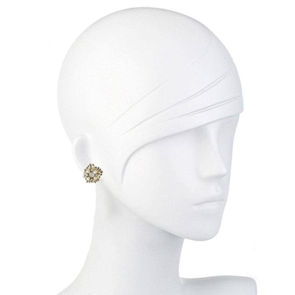 Elegant floral stud earrings on a mannequin, showcasing delicate pearl and gold accents.