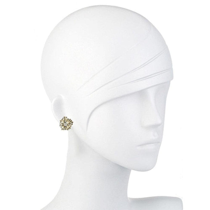 Elegant floral stud earrings on a mannequin, showcasing delicate pearl and gold accents.