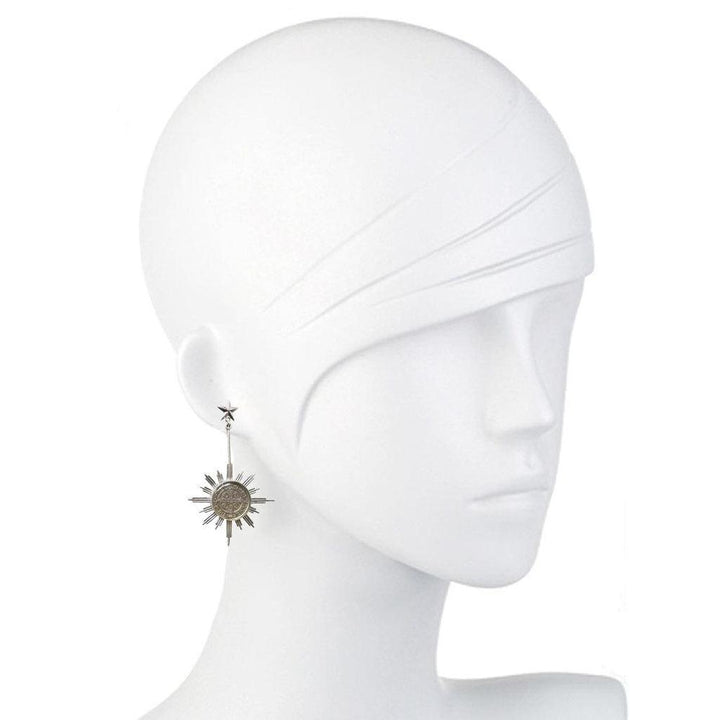 Silver sunburst earrings with star accents, displayed on a mannequin.