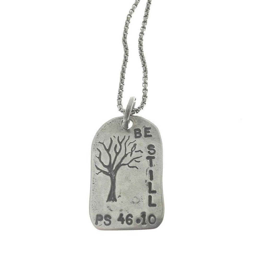 Silver "Be Still" necklace featuring a tree etching and Psalm 46:10.