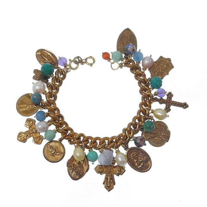 Gold charm bracelet with religious medallions, colorful beads, and pearls.